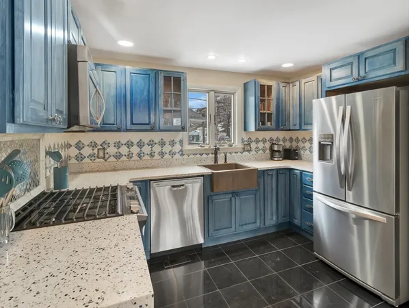 a kitchen with stainless steel appliances granite countertop a sink stove and refrigerator