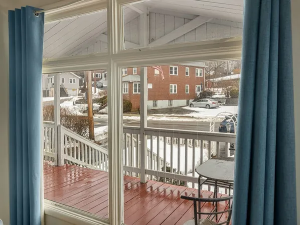 a living room with furniture a large window and wooden floor
