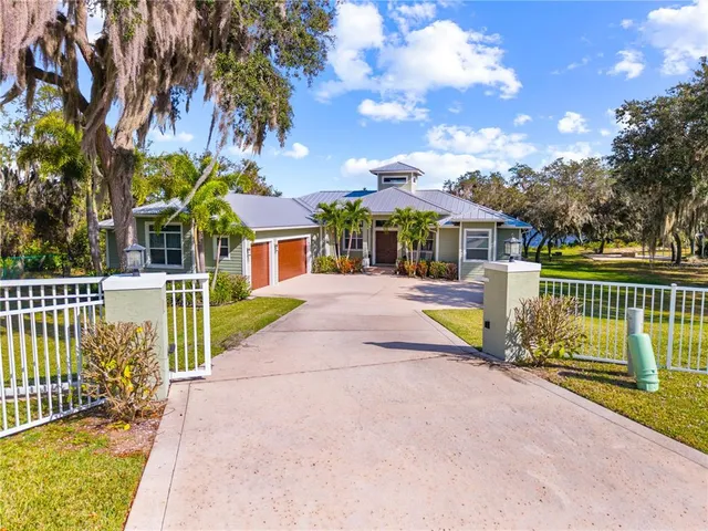 a view of a house with a yard and fence