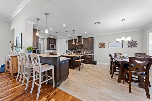 a kitchen with granite countertop a sink a counter space dining table and stainless steel appliances