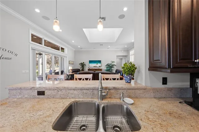 a view of a kitchen with stainless steel appliances granite countertop a refrigerator and a sink