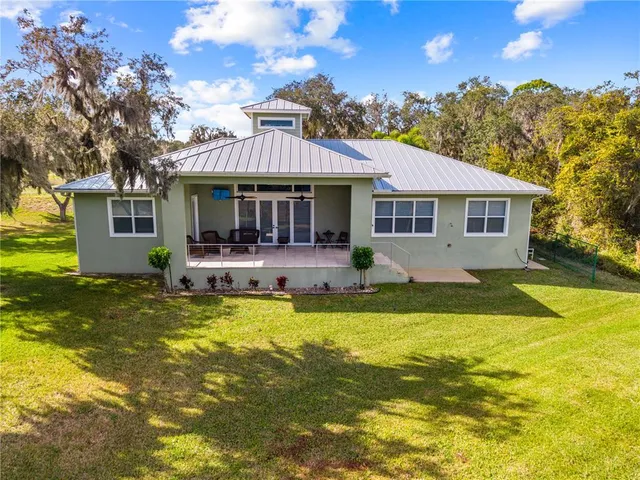 a front view of house with swimming pool and green space
