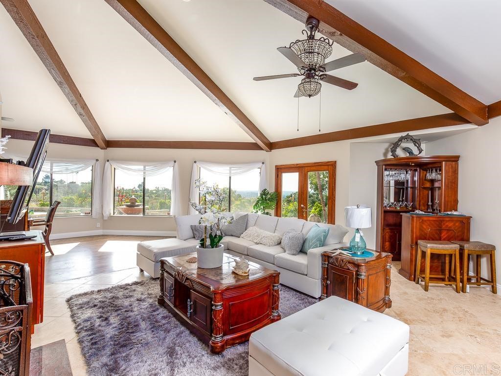 2070 Elevado Hills Drive Vista, CA 92084 - Photo 12 of 27 a living room with furniture a ceiling fan and a large window