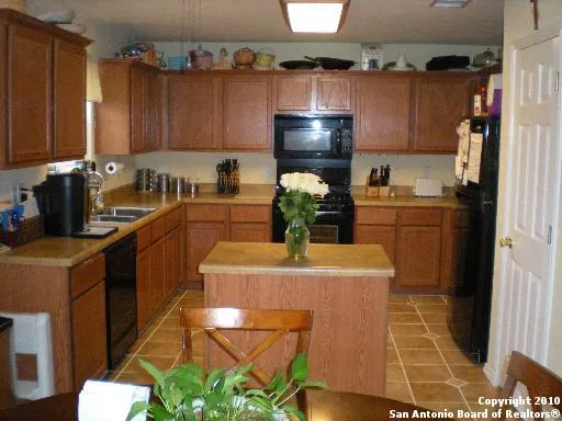 a kitchen with granite countertop a sink appliances and cabinets