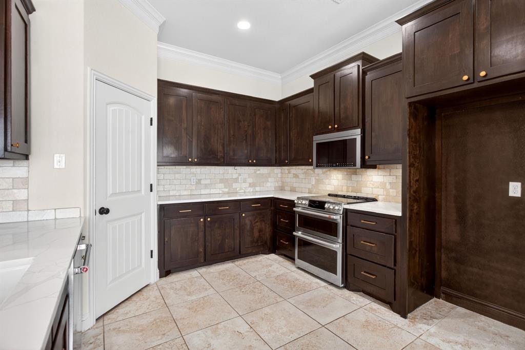 7320 Spring Ranch Court Godley, TX 76044 - Photo 17 of 38 a kitchen with stainless steel appliances granite countertop wooden cabinets a stove top oven a sink and dishwasher