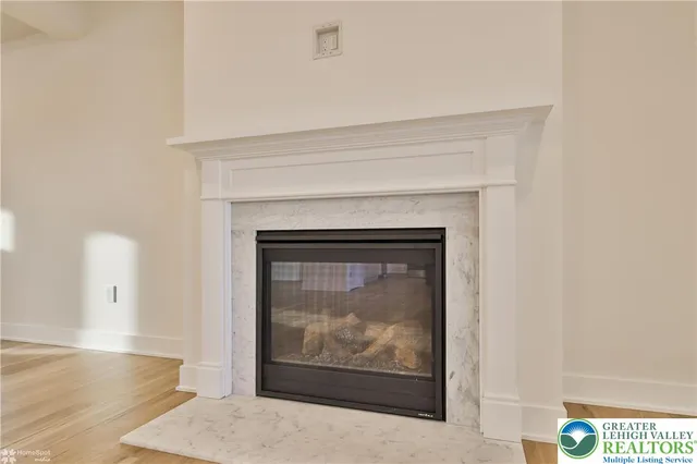 an empty room with wooden floor fireplace and windows