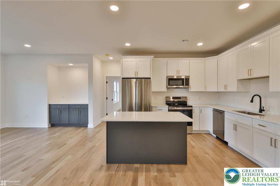 448 Long Lane Road Walnutport, PA 18088 - Photo 21 of 65 a large kitchen with stainless steel appliances a large counter top a stove a sink a refrigerator and a cabinets