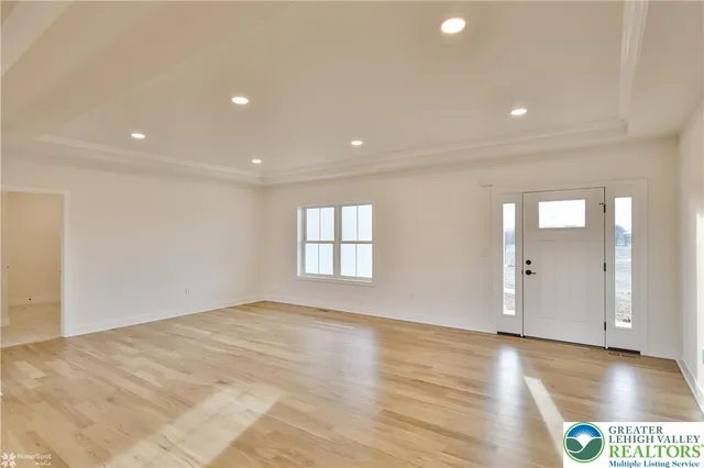 a view of a big room with wooden floor and windows