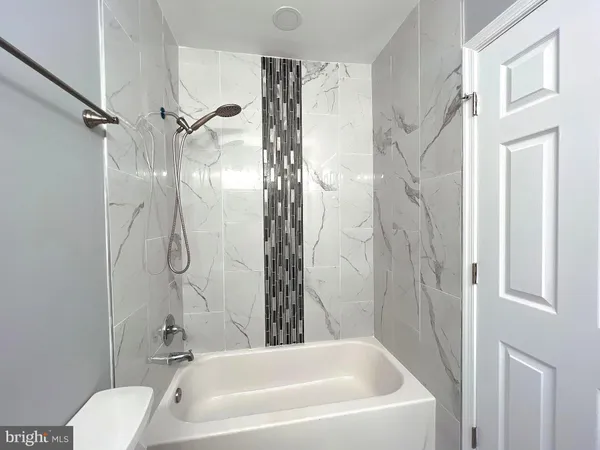 a bathroom with a white bath tub a shower and a toilet sink