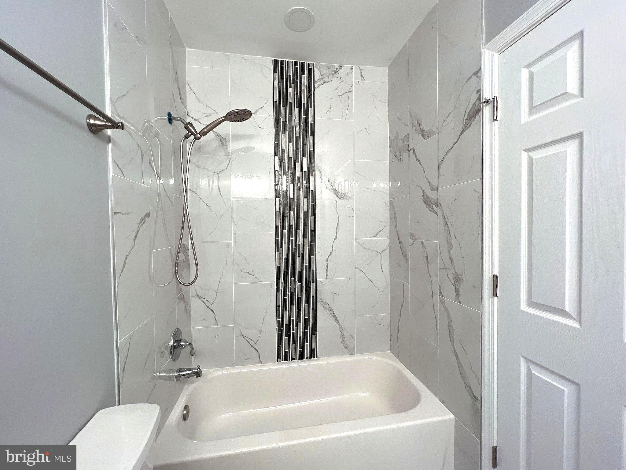 1210 Half Street Southwest Washington, DC 20024 - Photo 17 of 40 a bathroom with a white bath tub a shower and a toilet sink