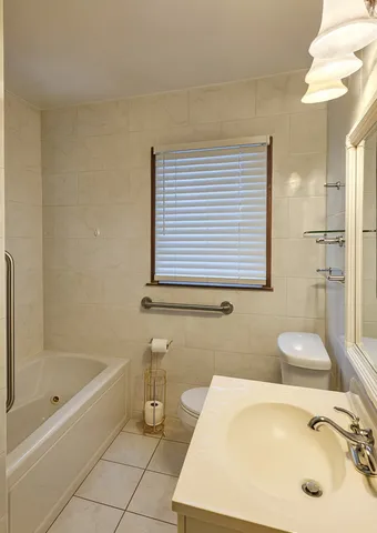 a bathroom with a tub sink and a mirror