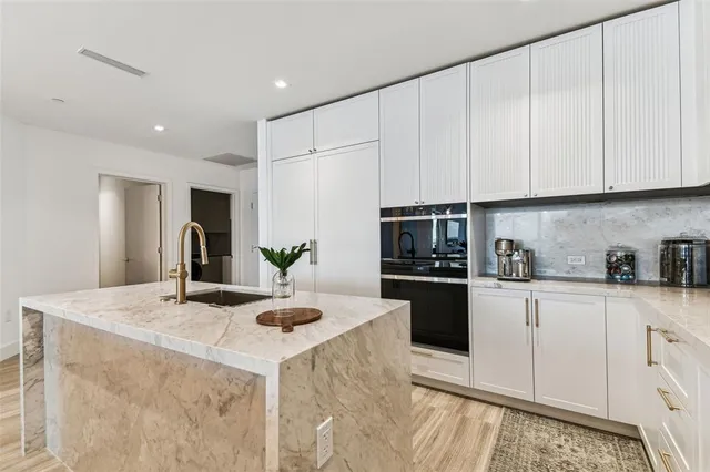 a kitchen with kitchen island granite countertop a white cabinets and white appliances