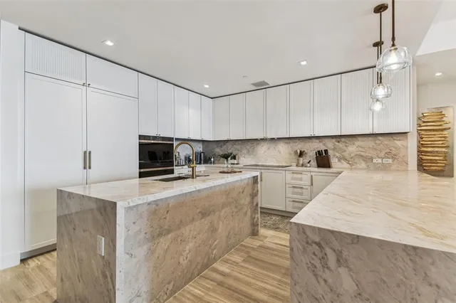 a kitchen with cabinets appliances a sink and a counter top space