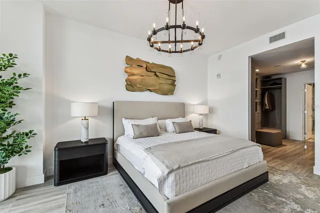 a bedroom with a bed and a chandelier