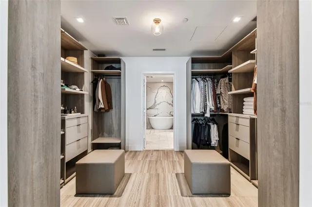 a view of walk in closet with clothes and shoes