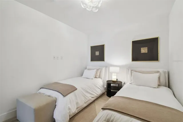 a bedroom with two beds and a chandelier