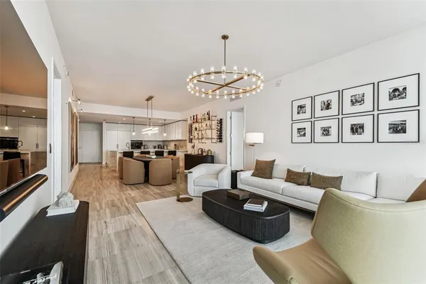 a living room with furniture kitchen and a chandelier