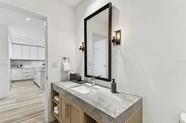 a bathroom with a granite countertop sink and a mirror