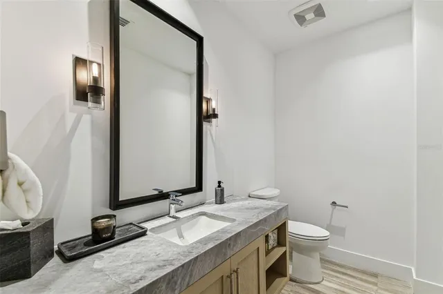 a living room with a mirror and a wooden floor