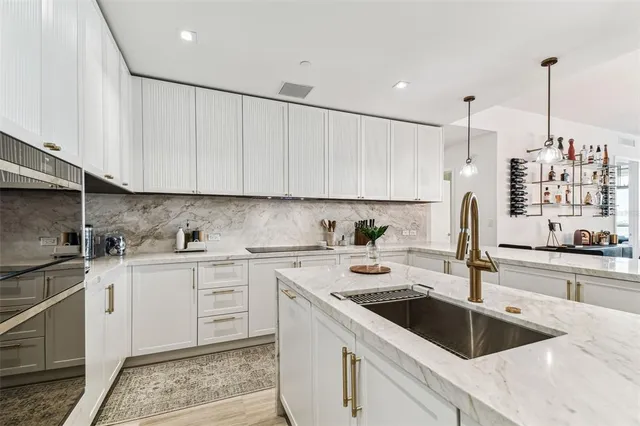 a kitchen with a sink cabinets and white appliances