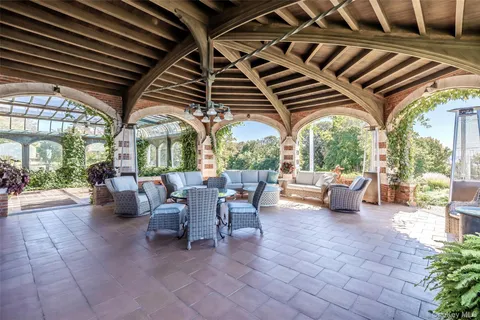 a view of a patio with table and chairs potted plants with large tree