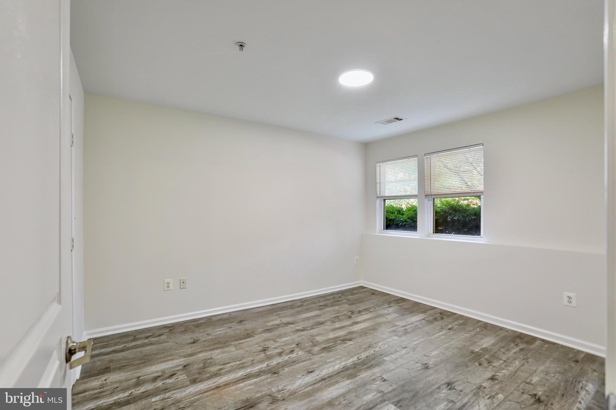 12001 Market Street, Unit T35 Reston, VA 20190 - Photo 11 of 23 a view of an empty room with wooden floor and a window