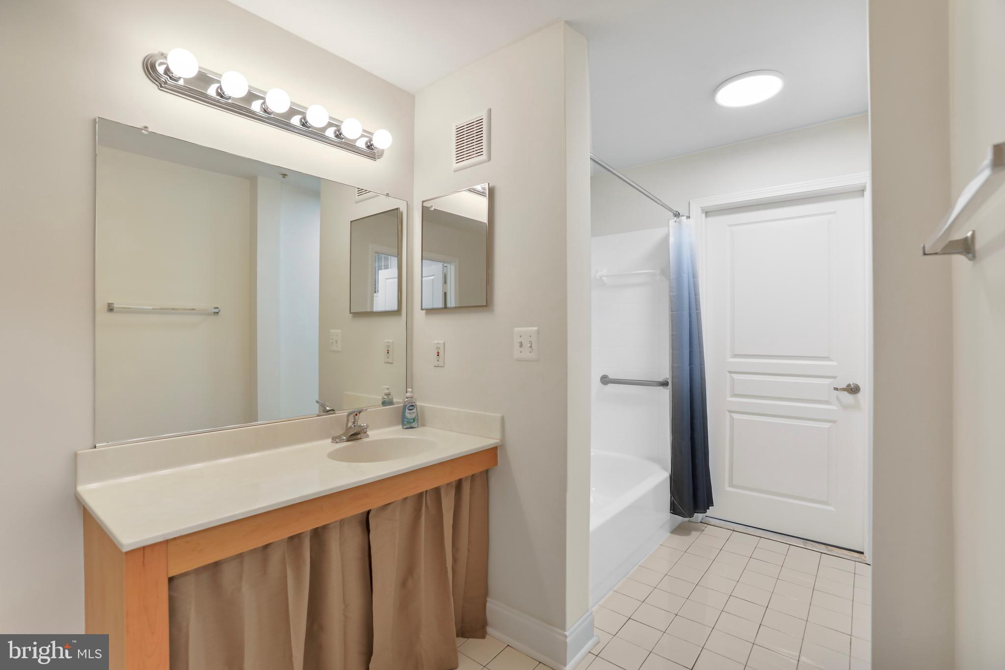 12001 Market Street, Unit T35 Reston, VA 20190 - Photo 13 of 23 a bathroom with a sink a shower and a mirror
