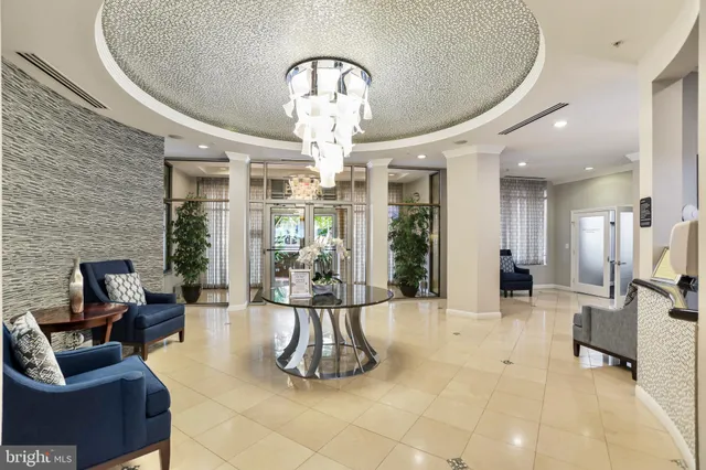 a lobby with furniture and a chandelier