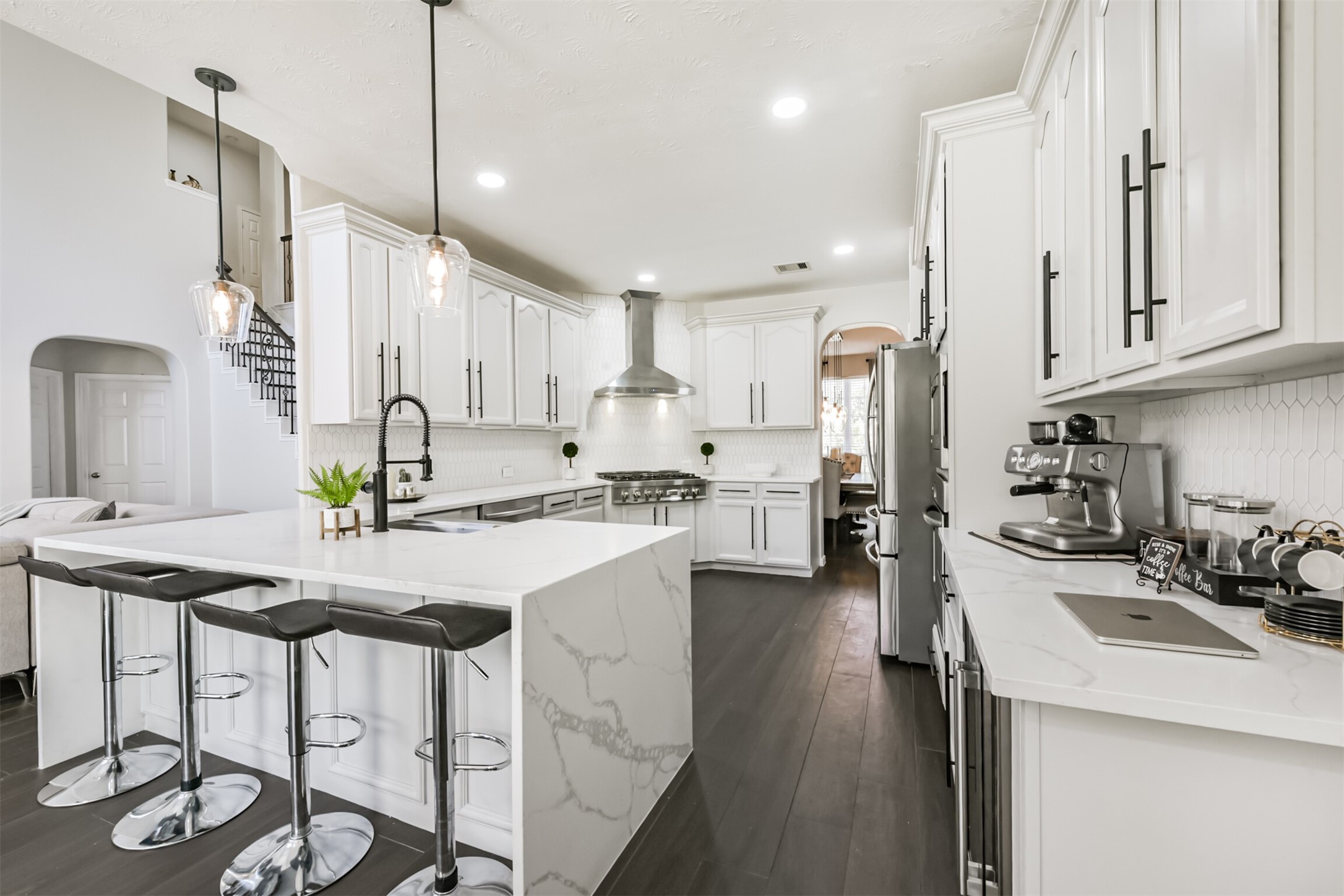 6806 Russelfield Lane Houston, TX 77049 - Photo 4 of 46 a kitchen with stainless steel appliances kitchen island granite countertop a sink a stove a refrigerator and chairs with wooden floor