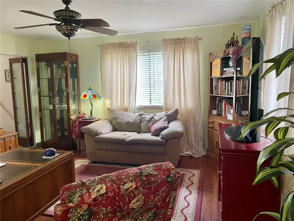 a living room with furniture a bookshelf and a window
