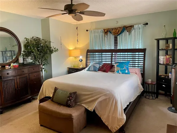 a bedroom with a bed a dresser and book shelfs