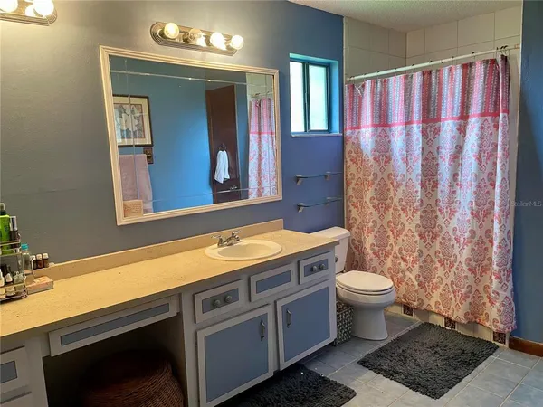 a bathroom with a granite countertop sink a mirror and a toilet