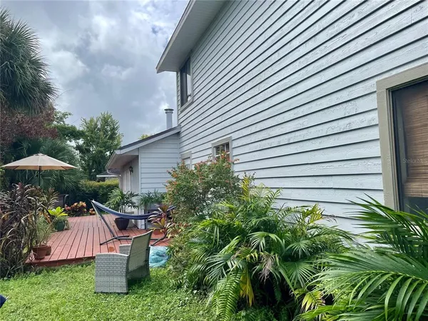 a view of a chair and table in backyard of the house
