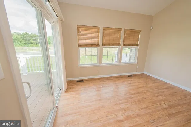 a view of a kitchen with kitchen island a sink wooden floor and a refrigerator