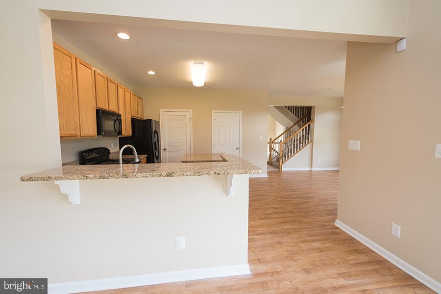 1406 Cat Tail Court Salisbury, MD 21804 - Photo 17 of 68 a view of a kitchen with kitchen island a sink wooden floor and a refrigerator