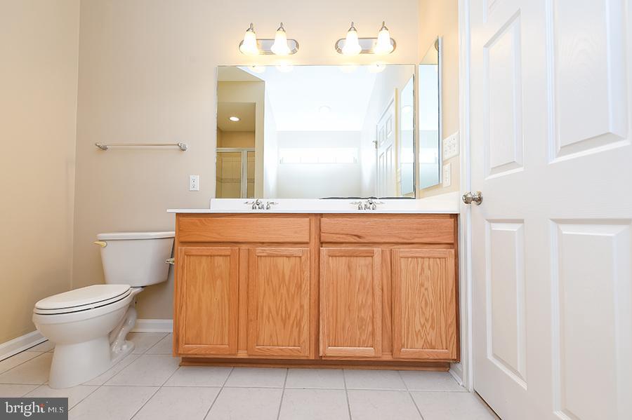 1406 Cat Tail Court Salisbury, MD 21804 - Photo 39 of 68 a bathroom with a toilet a sink and a mirror
