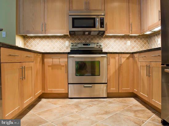 1406 Cat Tail Court Salisbury, MD 21804 - Photo 67 of 68 a kitchen with granite countertop a stove a sink and a microwave