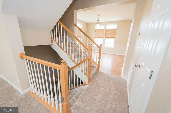 a view of staircase with lots of frames on wall and a window