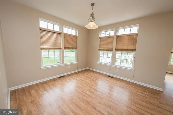 a view of a kitchen with wooden floor and electronic appliances