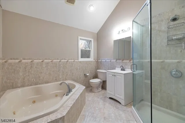 a bathroom with a bathtub sink mirror and toilet