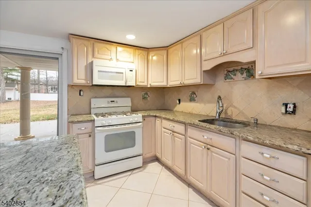 a kitchen with granite countertop white cabinets and white appliances