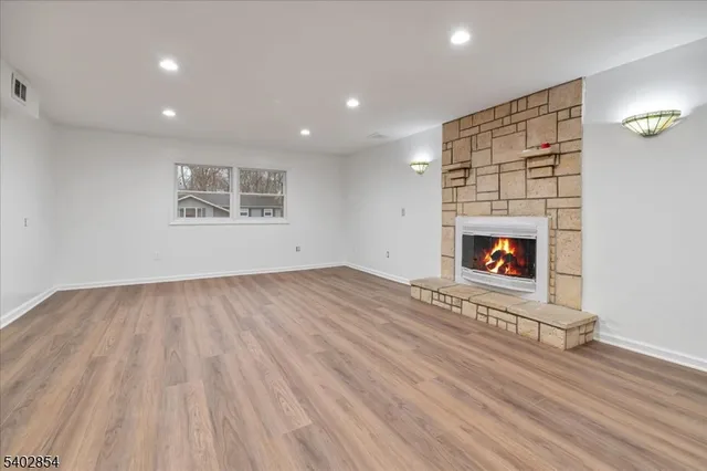 an empty room with wooden floor and a fireplace