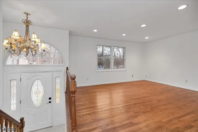 a view of empty room with wooden floor and window
