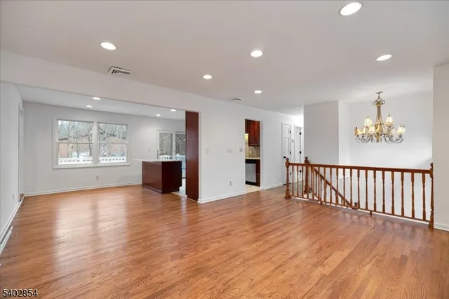 a view of a big room with wooden floor and windows