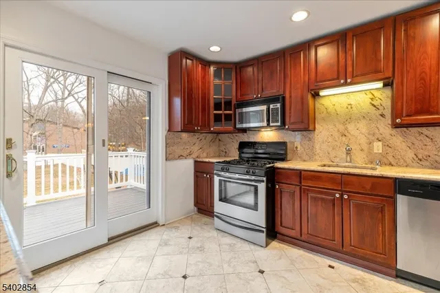 a kitchen with stainless steel appliances granite countertop a stove sink and microwave