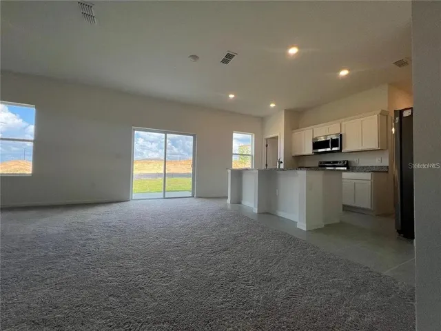 a kitchen with stainless steel appliances granite countertop a refrigerator and a stove top oven