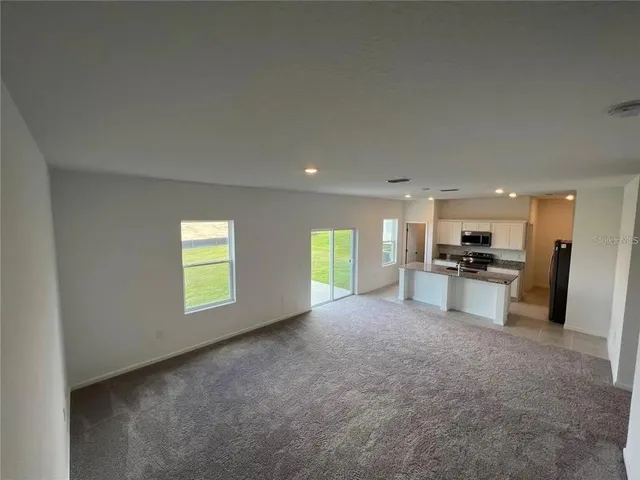 a view of a kitchen with refrigerator and windows