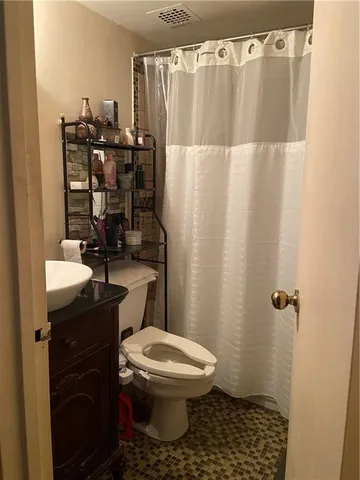 a bathroom with a sink a toilet a shower curtain and a shower