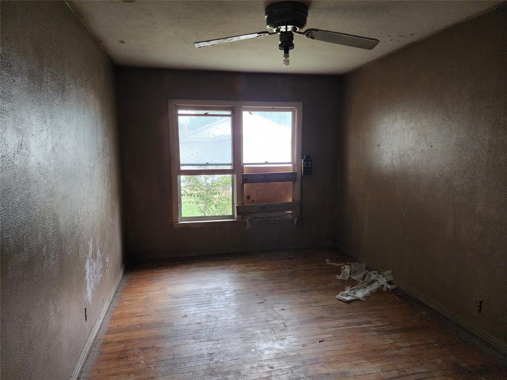 407 Largent Avenue Ballinger, TX 76821 - Photo 11 of 17 Spare room with wood-type flooring and a ceiling fan
