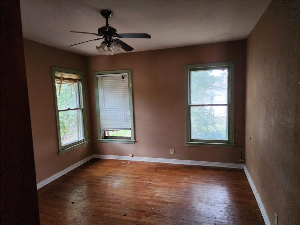 407 Largent Avenue Ballinger, TX 76821 - Photo 12 of 17 Spare room featuring hardwood / wood-style floors, healthy amount of natural light, and a ceiling fan